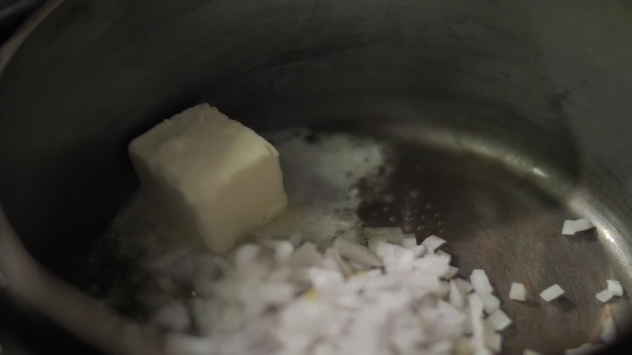 금속 팬에 버터로 다진 양파를 볶습니다.