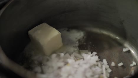 freír cebolla picada con mantequilla en una sartén de metal de cerca
