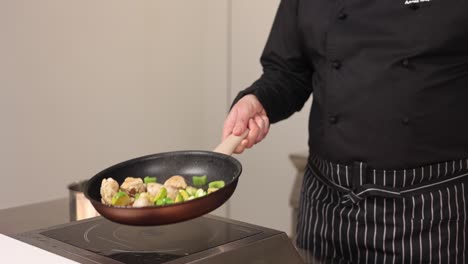 chef cooking chicken and vegetables