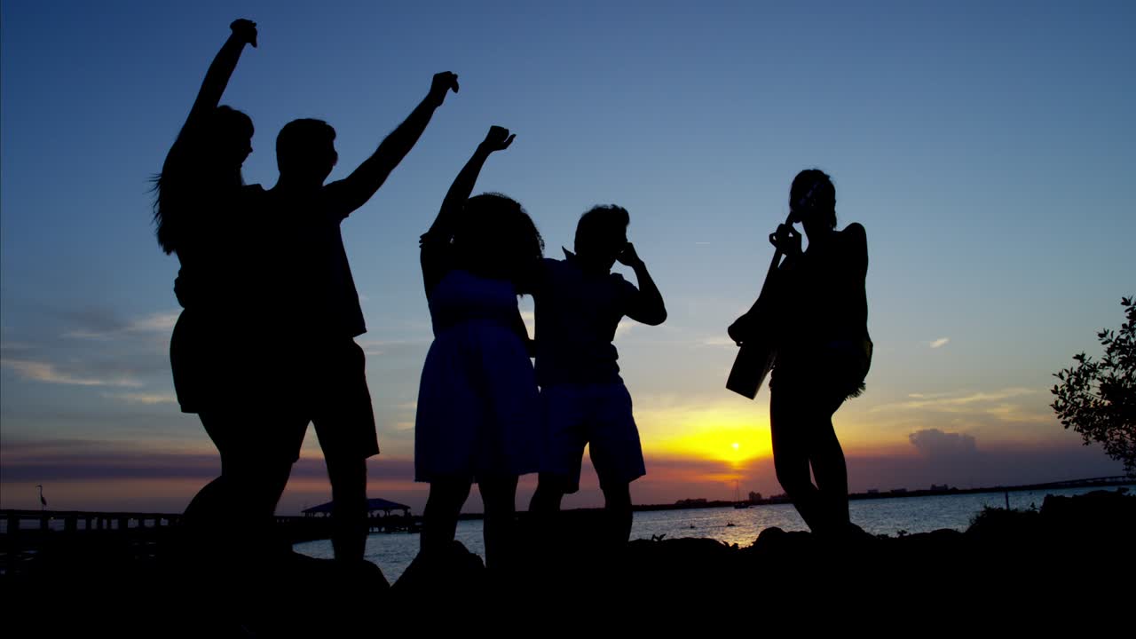 해변 파티를 즐기는 남성과 여성의 실루