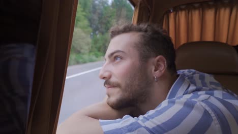 the man traveling in the back seat of the vehicle.