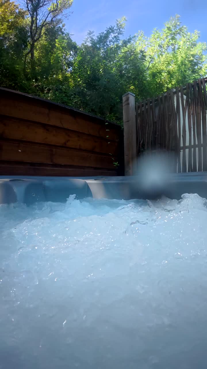 Acqua gorgogliante nella vasca idromassaggio in un giardino all'aperto