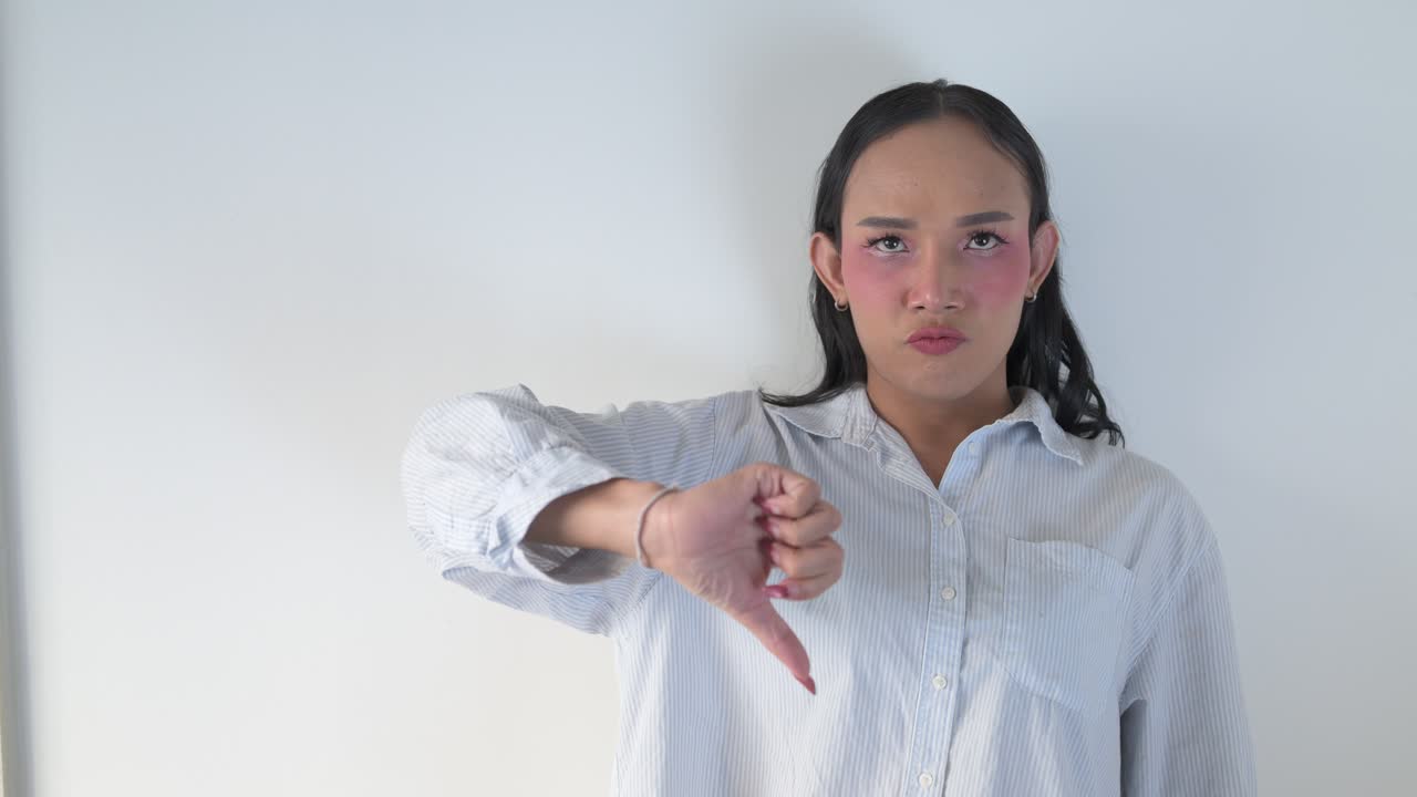 Thai transgender person giving thumbs down gesture and refusing something in business clothes
