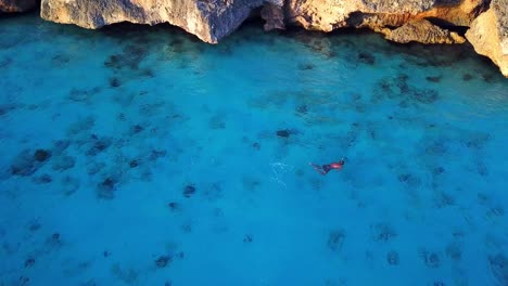 Vista-Aérea-De-Una-Persona-Buceando-En-La-Orilla-De-La-Playa-De-Cas-Abao,-Isla-Holandesa-De-Curacao-En-El-Caribe