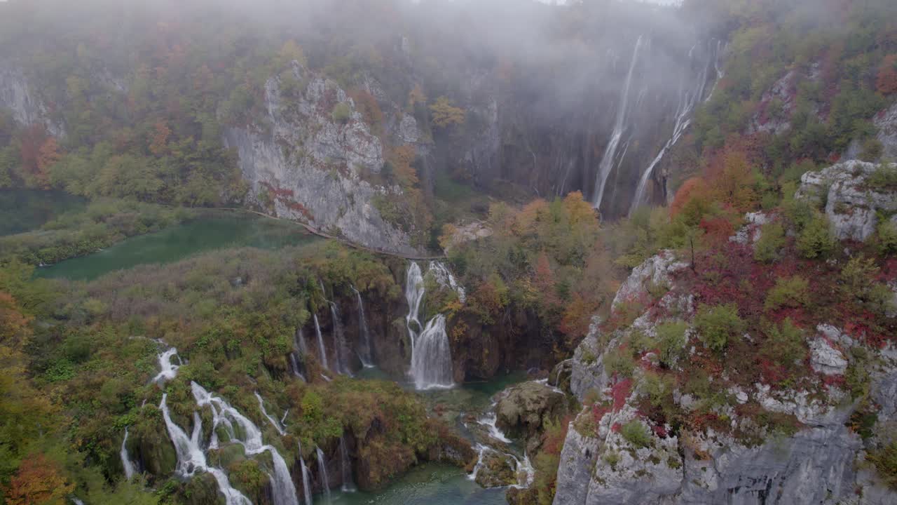 Nebbia leggera su cascate e un lago immobile nella foresta, Plitvice, Croazia