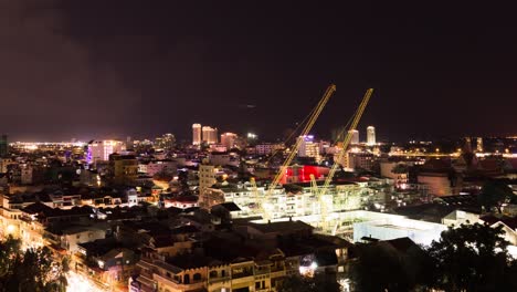 Paisaje-Urbano-De-Phnom-Penh-Por-La-Noche---Grúas-En-Primer-Plano,-Acercar