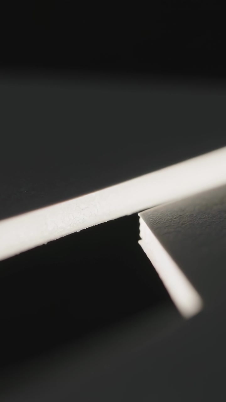 Vertical video: Entering short white edge sliding left, revealing notch beside strip on black