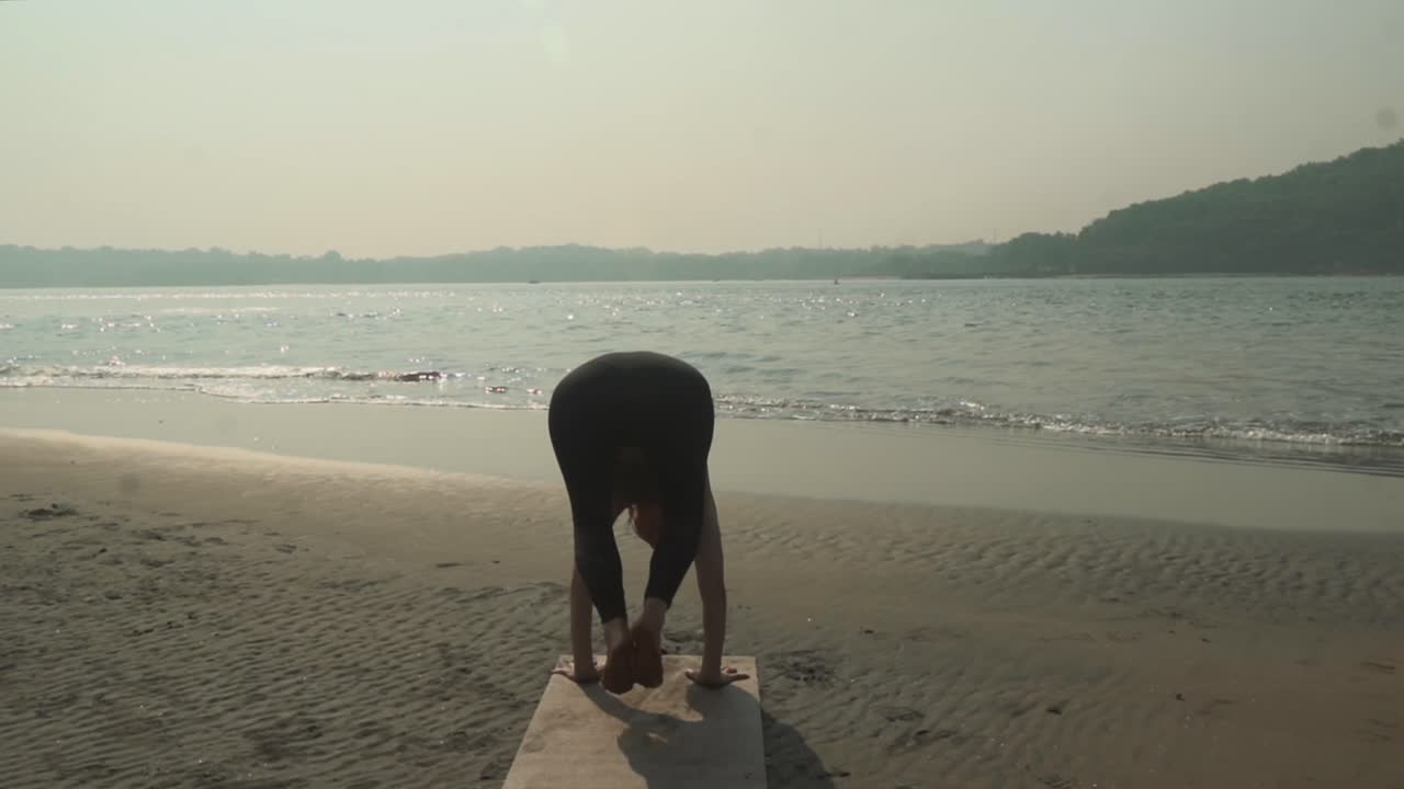 해변을 따라 빈야사 요가를 하는 소녀의 모습