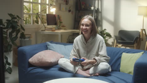 woman playing video games on a couch at home