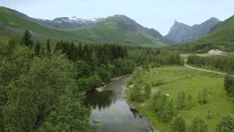 Paisaje-Rural-Con-Campo-Verde,-Río-Y-Montañas-Escénicas-En-Gudbrandsjuvet,-Noruega---Toma-Aérea-De-Drones