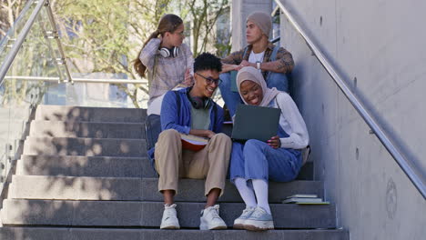 group of students studying together on campus stairs