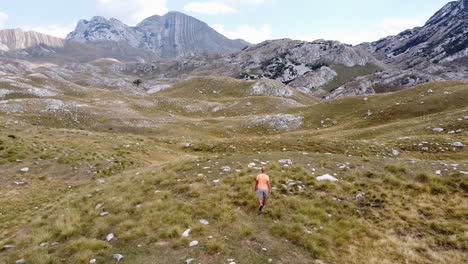 man walks at durmitor national park, montenegro - aerial dolly follow