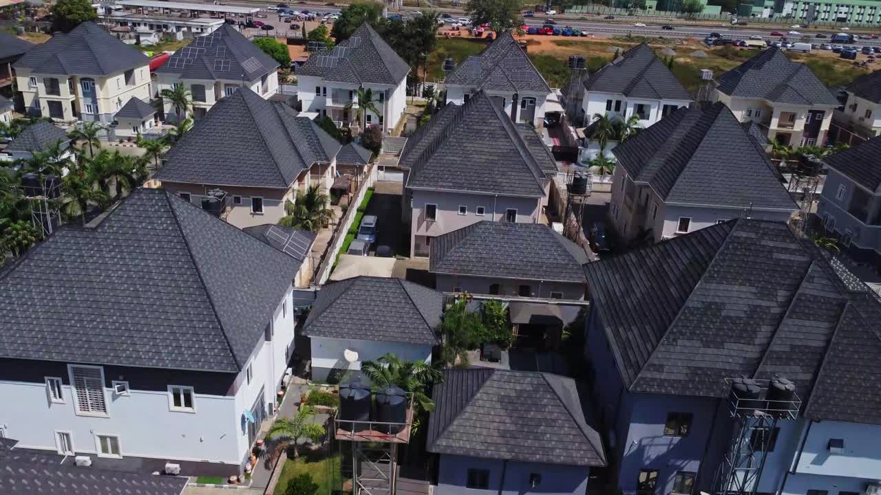 Krásný letecký záběr nových luxusních domů s velkými dvory v předměstské čtvrti v Abuji, Nigérie za slunečného dne.