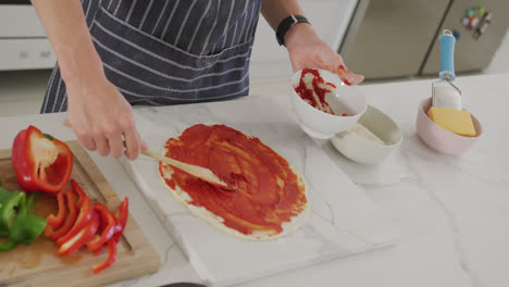 Asian-male-teenager-preparing-food-and-wearing-apron-in-kitchen