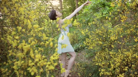 una bailarina entre los árboles y las flores baila a cámara lenta