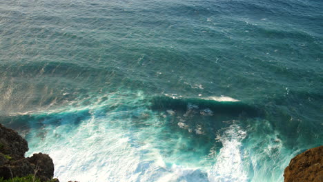 powerful ocean waves crashing against rocky cliffs, creating white foam against the deep blue sea in madeira aerial view of the rugged coastline and the raw, untamed beauty of nature