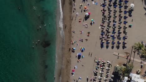 drone top shot rising over a beach in marbella