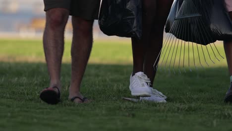 voluntarios alegres con rastrillos y bolsas