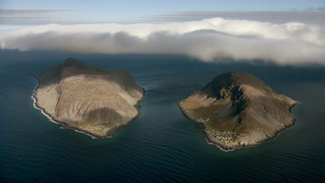 aerial view of two remote islands with settlements and a distinct cloud formation