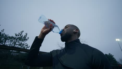 man drinking water after exercise