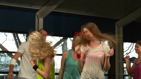 grupo de fitness saltando y riendo en el gimnasio