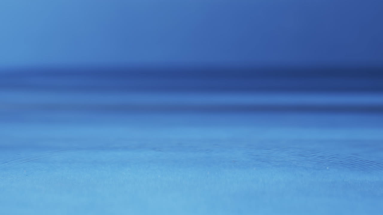 Vídeo de close-up de gotas de água com espaço para texto em fundo azul