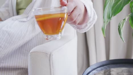 happy caucasian plus size woman drinking cup of tea in slow motion