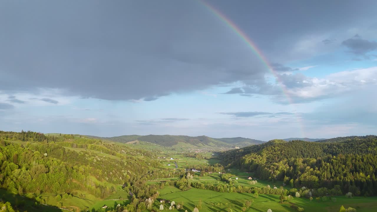 Scenic valley in Romania with rainbow and forests