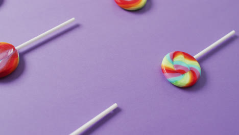 video of rows multicoloured lollipops on blue background