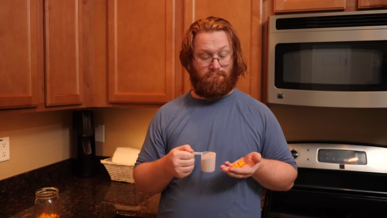 hombre de cabello rojo que muestra polvo de proteína de suero y bocanadas de proteína del suero.