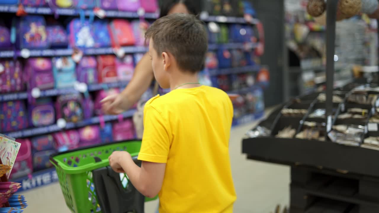 Boy shopping to school. Portrait of boy choosing stationery in the store
