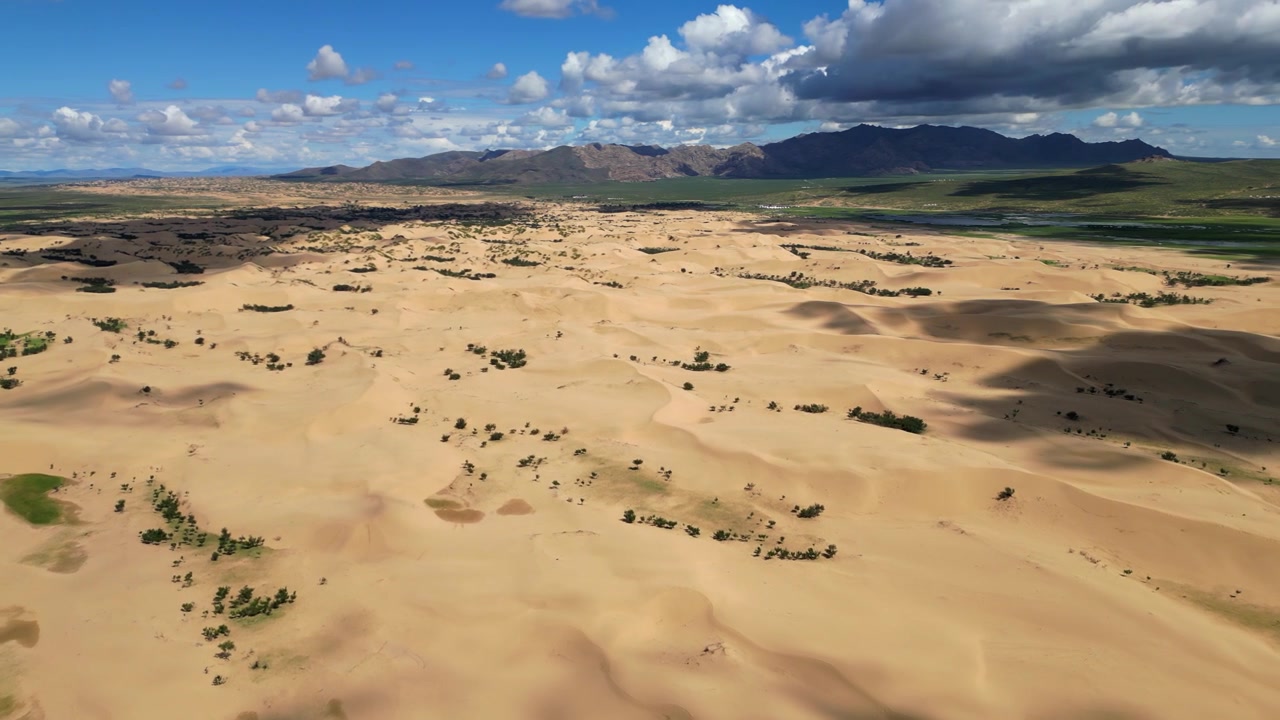 Sorvolo del deserto del Mini Gobi circondato da steppa verde e montagne.