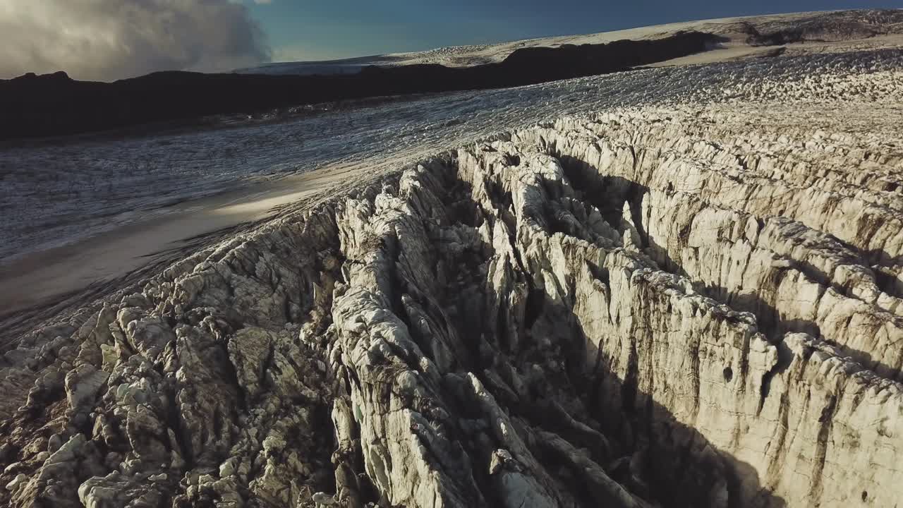 vista aérea sobre la superficie de hielo texturizada de un glaciar islandés, al anochecer