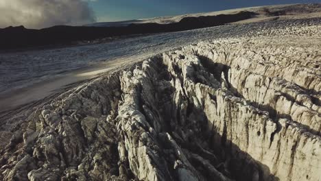 Aerial-view-over-the-textured-ice-surface-of-an-icelandic-glacier,-at-dusk