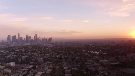 wide aerial shot panning from setting to sun to downtown los angeles skyline