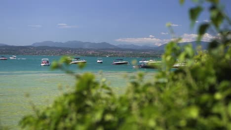 wide establishing shot of boats docked together in the lake, on jamaica beach, sirmione, lago garda, lake garda, italy