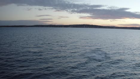 Whale-watching-off-Sydney-Northern-Beaches-Coastline-during-sunset,-Aerial-drone-footage-of-Humpback-Whale-breaching-and-playing-around-during-migration