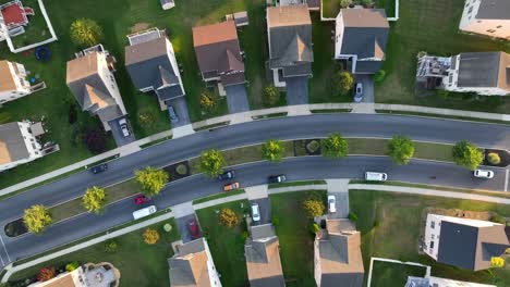 top down aerial shot of cars driving through american neighborhood of townhouses