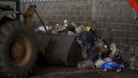 una excavadora carga residuos en la cuchara