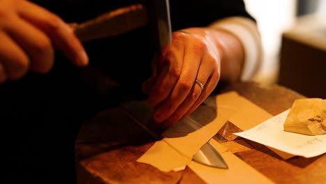 hands sealing an envelope with a wax stamp.