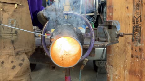 Close-up-shot-of-a-welder-welding-a-metal-pipe