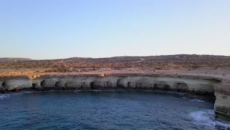 aerial shot of beautiful sea caves at a picturesque seacoast