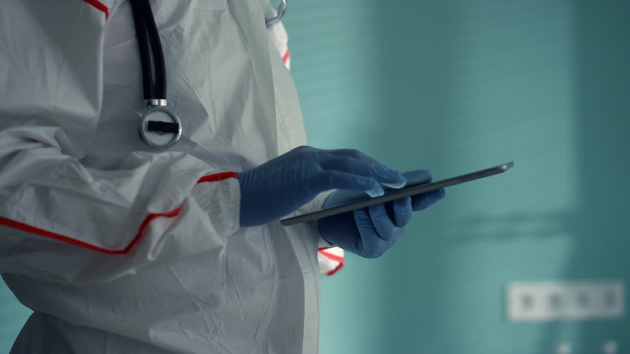 Physician hands using tablet computer in infectious hospital unit close up.