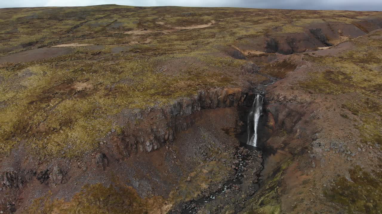 imágenes aéreas que se acercan a una majestuosa cascada ubicada en las montañas de islandia