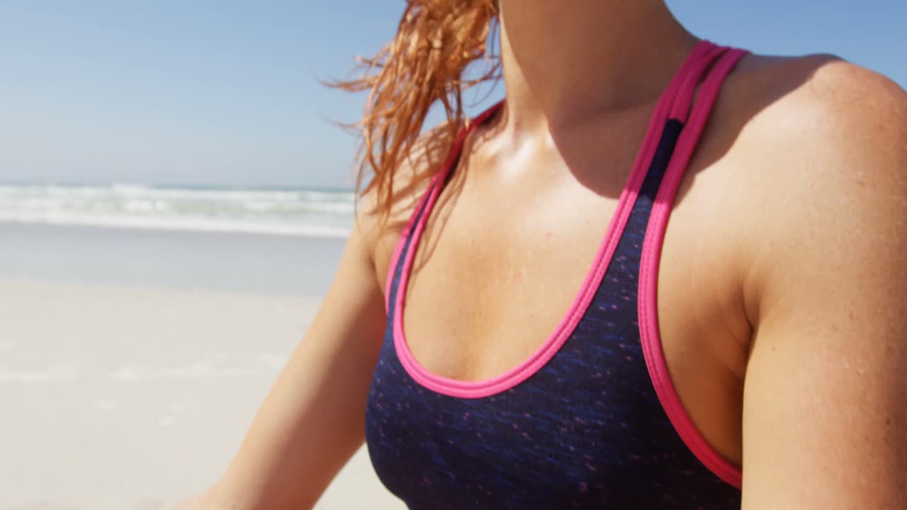 mujer realizando yoga en la playa en un día soleado 4k