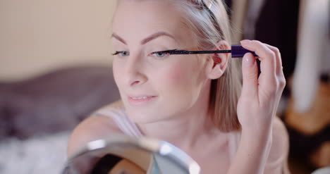 woman doing makeup painting eyelashes with mascara 12