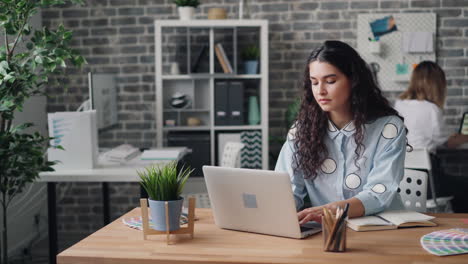 mujer trabajando en una computadora portátil en una oficina moderna