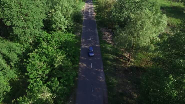 Vista aerea di un'auto che guida su una strada di campagna