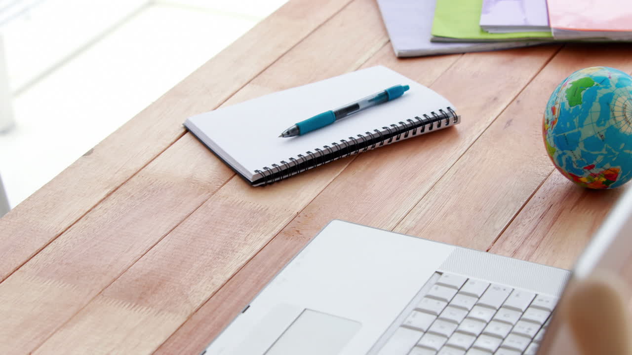 Upward view of a laptop and notebook on a desk