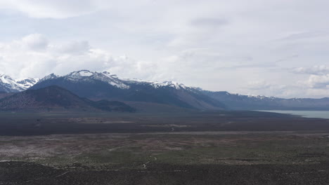 Montañas-Cubiertas-De-Nieve-Y-Vastas-Llanuras-Bajo-Un-Cielo-Nublado-En-La-Región-Montañosa-Del-Cráter-De-California